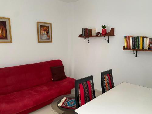 a living room with a red couch and two chairs at Dar Saïda Guest house in Tunis