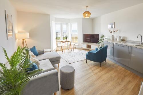 a living room with a couch and a kitchen at Glenholme Apartments with Sea Views and Balconies in Redcar North Yorkshire in Redcar