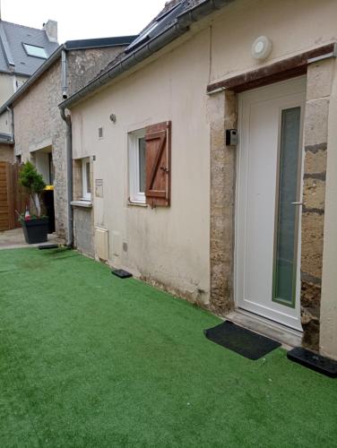 a yard with green grass next to a house at la parenthèse in Sainte-Mère-Église