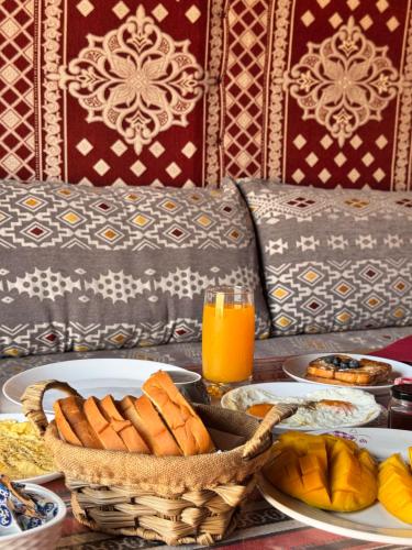 BadīyahQuiet Nights Camp的一张桌子上摆着一盘盘食物和一篮面包