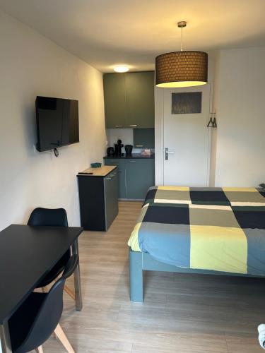 a bedroom with a bed and a desk and a kitchen at Eindhoven4you in Eindhoven