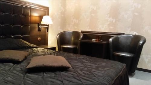 Un dormitorio con una cama y dos sillas y un escritorio. en Hotel Chamishki, en Blagoevgrad