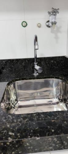 a sink with a faucet on top of a counter at Apartamento na praia in Itapema