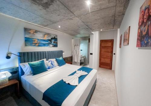 una camera da letto con un letto grande con cuscini blu di Boutique Hotel Luz da Lua a Ponta do Sol