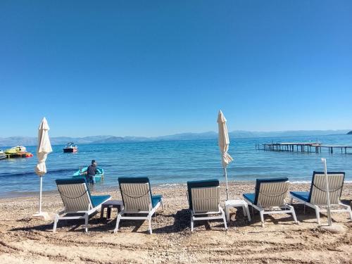 a group of chairs and umbrellas on a beach at Spiros dream house in Mesongi
