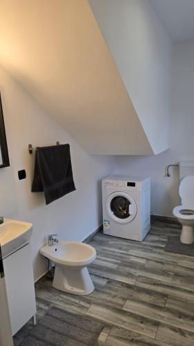a bathroom with a toilet and a washing machine at Casa 2 Magurele in Măgurele