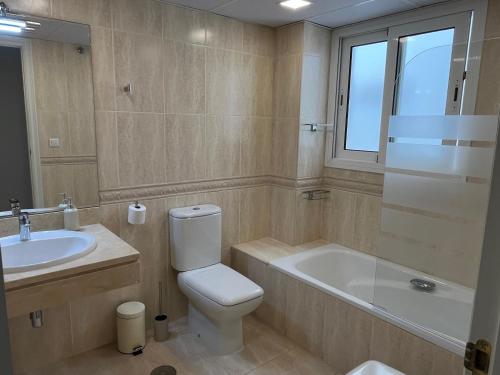 a bathroom with a toilet and a tub and a sink at Carvajal casa Tucan in Fuengirola