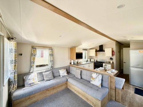 a living room with a couch and a kitchen at Willerby grasmere in Little Clacton