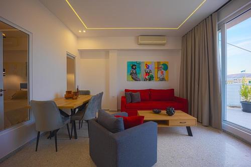 a living room with a red couch and a table at Piraeus Harbor Hideaway in Piraeus