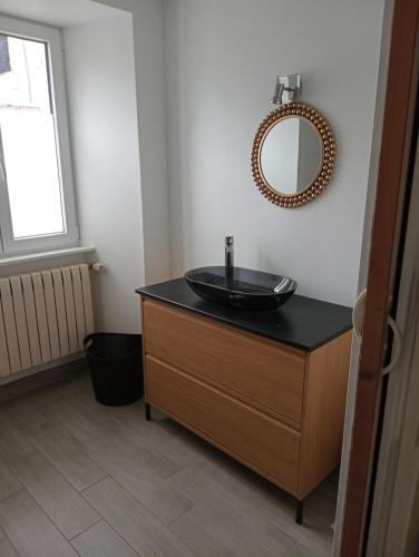 a bathroom with a sink and a mirror on a dresser at la parenthèse in Sainte-Mère-Église