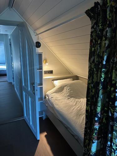 a small bed in a room with an open door at Pilvägen 7 Ekerö - Skå in Skå