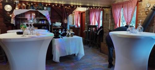 a room with two white tables with wine glasses at Luxury suites Marušić sobe 