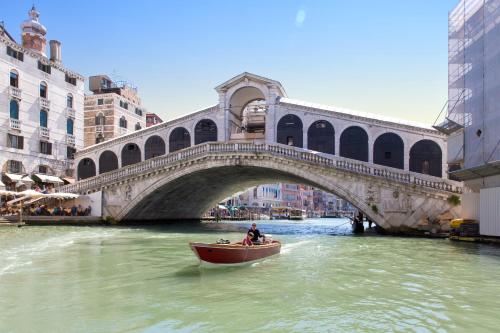 a boat in the water in front of a bridge at Aquamare, boutique b&b in Venice