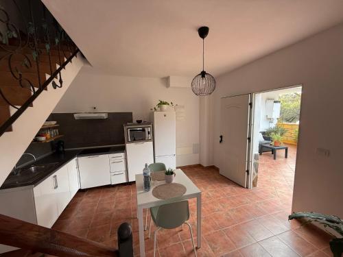 a kitchen with white cabinets and a table with chairs at Estudio las lajas in Chío