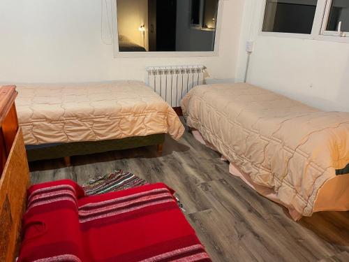 una habitación con dos camas y un espejo en Cabaña Familia de Campo 3, en El Chaltén