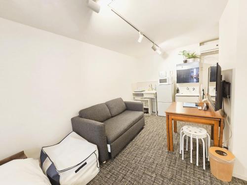 a living room with a couch and a table at 2025年10月リニューアル! SLEEPLAB駒込-Komagome- in Tokyo