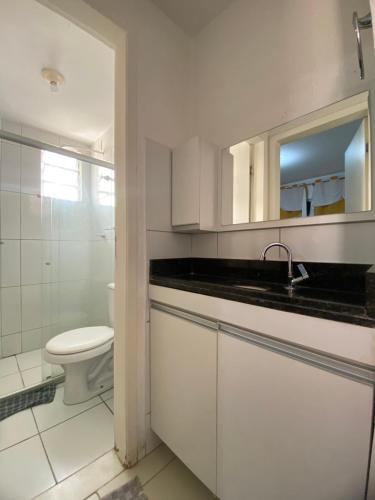 a white bathroom with a sink and a toilet at Residencial Mais Viver São Francisco in Petrolina