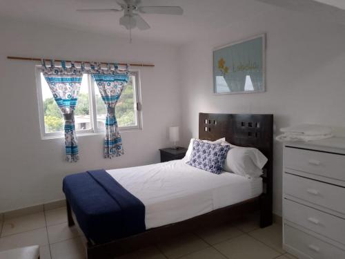 a bedroom with a bed and two windows at Casa el Refugio de las Flores in Oaxtepec