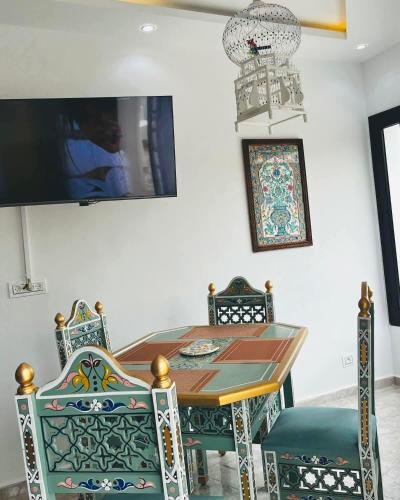 mesa de comedor con sillas y TV en Dar houriya, en Tabarka
