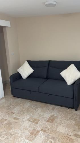a blue couch in a living room with two pillows at O'Briens Luxury Studio City Centre in Galway