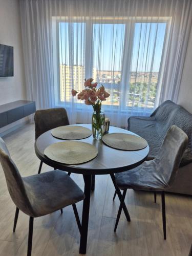 a living room with a table with a vase of flowers at Апартаменти на Марсельській 62 в ЖК Острова, 1 спальня та кухня-студія in Odesa