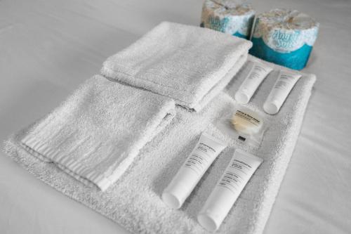 una toalla blanca con dos cepillos de dientes y una botella de pasta de dientes en Nautical home with pool, grill and steps to shops, en Marco Island