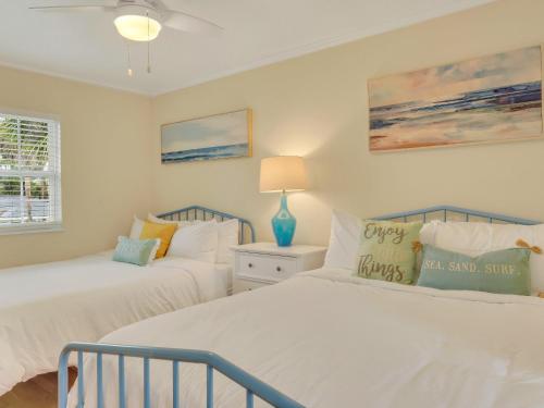 ein Schlafzimmer mit zwei Betten und einem Tisch mit Lampe in der Unterkunft Sea Stallion in Tybee Island