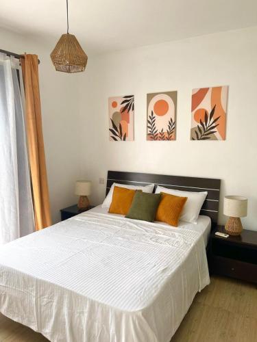 a bedroom with a bed with orange and green pillows at Appartement chaleureux avec jardin et piscine in Albion