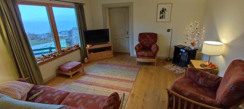 un salon avec un canapé et une télévision dans l'établissement The Hirsel on Skye, à Ord