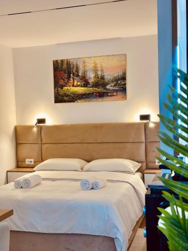 a bedroom with a bed with two towels on it at Lois Apartment in Tirana