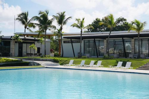a house with a swimming pool in front of a building at Luxury Villa in Vista Cana with Private Pool and BBQ in Punta Cana