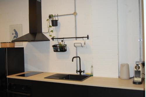 a kitchen counter with a sink and a stove at Beautiful studio near the station in London