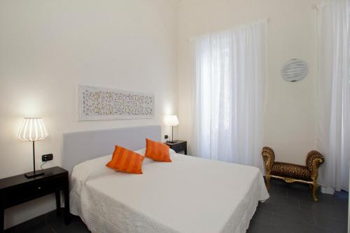 una camera da letto con un letto bianco e cuscini arancioni di Canto dei Mille a Firenze