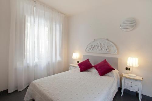 1 dormitorio con 1 cama blanca y 2 almohadas rojas en Canto dei Mille, en Florencia