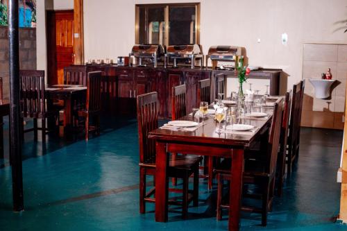 a dining room with a wooden table and chairs at Nguchiro Palace Hotel in Moshi