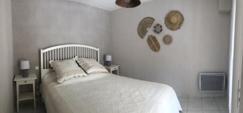 a bedroom with a white bed and two night stands at Chez Christine et Jean-Louis in Fouras