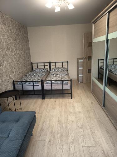 zwei Betten in einem Zimmer mit Holzboden in der Unterkunft Vieno kambario butas Šiauliuose in Šiauliai