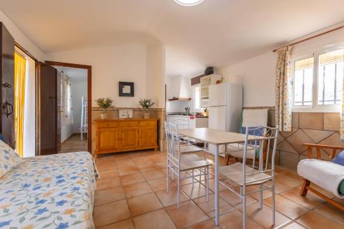 eine Küche und ein Wohnzimmer mit Tisch und Stühlen in der Unterkunft La casita del Abuelo in Guadalcanal