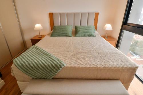 een slaapkamer met een groot bed met 2 groene kussens bij A luxury space to make you feel at home in Asuncion