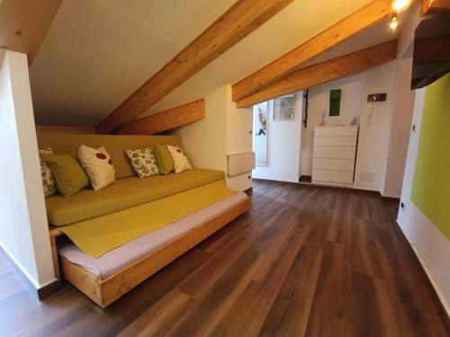 a bedroom with a couch in a room with wooden floors at Mansarda in Centro in Turin