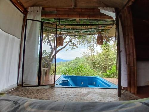 Zimmer mit Blick auf den Pool durch ein Fenster in der Unterkunft Eco Ortalis Villeta in Estación El Salto