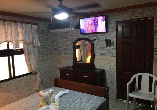a bedroom with a doll on a bed and a mirror at Apart-Hotel Costa Verde in Costa Verde