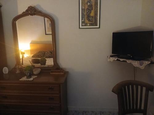 a bedroom with a dresser with a mirror and a television at Dream of Eden in Rome