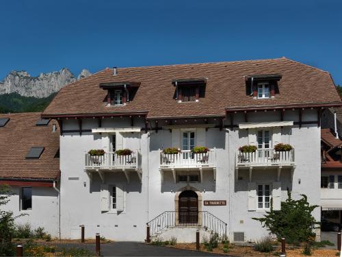 a large white building with windows and balconies at Hôtel Beau Site Talloires B SPA in Talloires