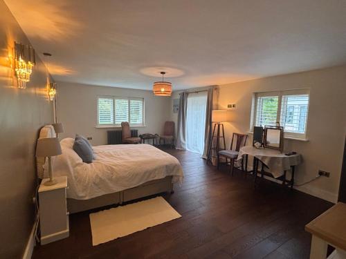 a bedroom with a bed and a table and chairs at Boycott House in Shalstone