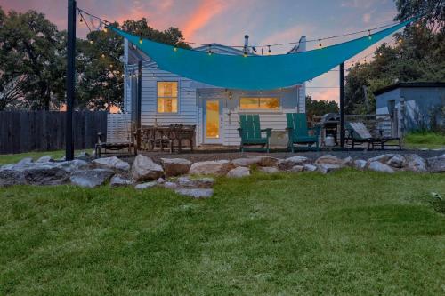 a tiny house with a hammock and chairs in a yard at Hill Country RelaxStation Getaway in Morris Ranch