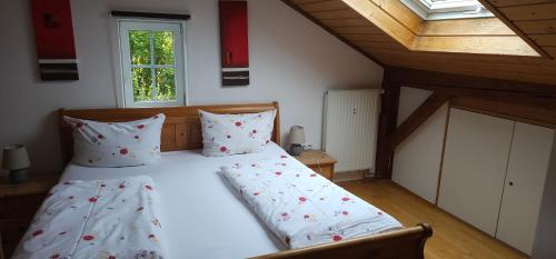 - une chambre avec un lit doté de draps blancs et d'oreillers rouges dans l'établissement Casa Patrizia, à Schwangau