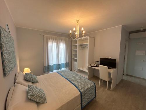 a bedroom with a bed and a desk and a window at Domu Jole B&B in Selargius