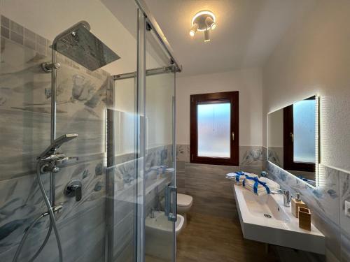 a bathroom with a shower and a sink and a toilet at Domu Jole B&B in Selargius