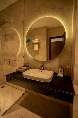 a bathroom with a sink and a mirror at Betworld Casino & Hotel in Krong Poi Pet